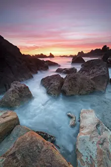 North America, USA, Oregon. Sunset and incoming tide at Harris Beach State Park, ORrocks at arch