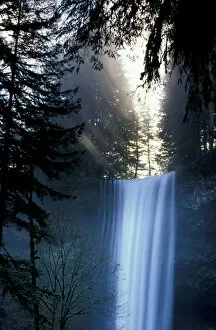 North America, USA, Washington. Waterfall with rays of light shining through mist
