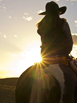 Multicolor Prints: North America; USA; Wyoming; Shell; Big Horn Mountains; Cowgirl in silouette with sunset