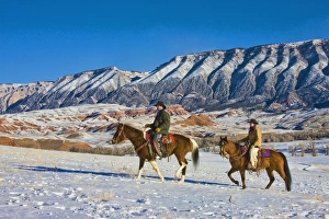 North America; USA; Wyoming; Shell; Cowboy and Cowgirl riding Horse through the Snow