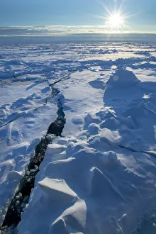 Norway. Icescape at 84 degrees north, crack in ice with sunburst