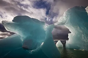 Images Dated 14th August 2008: Norway, Svalbard, Spitsbergen Island, Morning sun lights melting arched iceberg floating