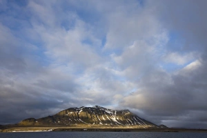 Images Dated 25th July 2008: Norway, Svalbard, Spitsbergen Island, Setting sun lights clouds above eroded cliffs