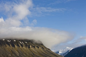 Images Dated 25th July 2008: Norway, Svalbard, Spitsbergen Island, Setting sun lights clouds above eroded cliffs
