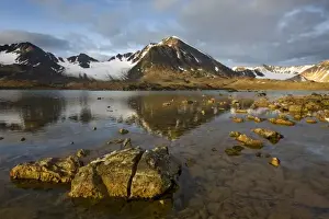 Norway, Svalbard, Spitsbergen, Rising midnight sun lights glacier-covered mountains