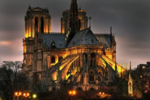 Basilica Prints: Notre Dame Cathedral and the Seine River shimmer in the Paris, France. night
