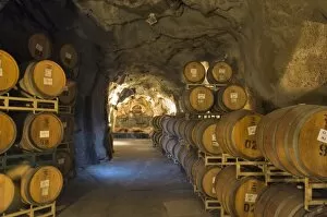 Oak aging barrels in cavern at Ironstone Winery, near Murphys, Calaveras county, California, USA