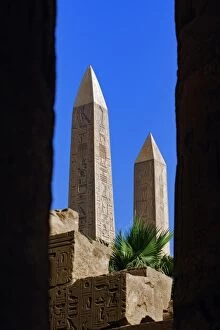 The two Obelisks of Queen Hatshepsut viewed between columns of the Hypostyle Hall
