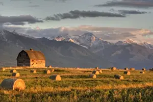 Images Dated 24th September 2007: Old barn framed by hay bales and dramatic Mission Mountain Range in Montana