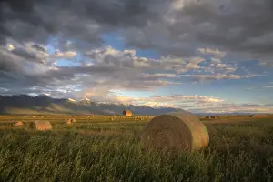 Images Dated 24th September 2007: Old barn framed by hay bales and dramatic Mission Mountain Range in Montana