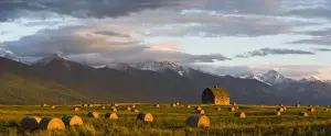 Images Dated 24th September 2007: Old barn framed by hay bales and dramatic Mission Mountain Range in Montana