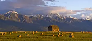 Images Dated 24th September 2007: Old barn framed by hay bales and dramatic Mission Mountain Range in Montana