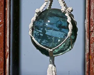 Latrabjerg Prints: Old-fashioned glass float used in fishing nets hangs in window near Latrabjerg, Iceland