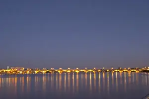 The old Pont de Pierre bridgeat night with reflections in Bordeaux on the Garonne