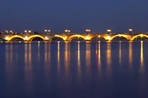 The old Pont de Pierre bridgeat night with reflections in Bordeaux on the Garonne River