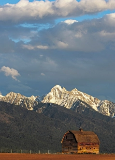 Mission Valley Prints: Old wooden barn and Mission Mountains near Pablo, Montana, USA. (Editorial Use Only)