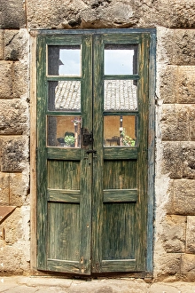 Inca Prints: Old wooden door with worn out green paint nestles between walls built by the Inca in the 1440's in Ecuador