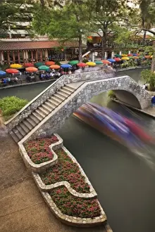 Images Dated 5th April 2006: Outdoor cafe along River Walk and boat in motion passing under bridge over San Antonio River