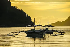 Outrigger at sunset in the bay of El Nido, Bacuit Archipelago, Palawan, Philippines
