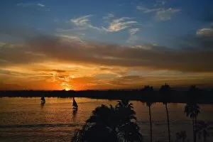Images Dated 22nd November 2005: Pair of falukas and sightseers on Nile River at sunset, modern day Luxor, or ancient