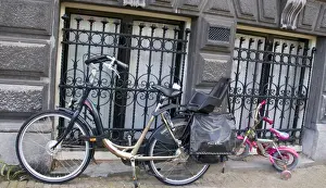 Marilyn Parver Prints: Two parked bikes including a pink child sized bike with Training Wheels