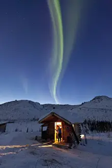 Images Dated 10th March 2011: A person stands in the doorway of the Caribou Bluff cabin and watches in awe as