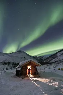 Cabin Prints: A person stands in the doorway of the Caribou Bluff cabin and watches in awe as