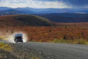 Gravel Road Prints: Pickup camper driving on the Top of the World Highway between Dawson City / Yukon