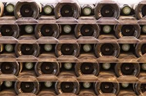 A pile of bottles stacked high with the bottle bottoms and bottle necks. Tax stamp