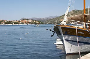 Pleasure boats moored on buoys and along the key, villas along the coast. Mountains