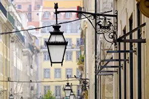 Portugal, Lisbon. Wrought iron street lights on corner of building. Maritime emblem