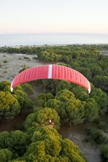Powered paraglider flying over maquis shrubland in Demre, aerial view, Antalya, Turkey