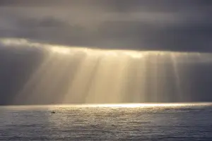 Santa Cruz Prints: Rays emit from the clouds over the Pacific Ocean as fishing boat passes by near Santa Cruz