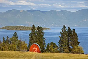 Red barn sits along scenic Flathead Lake near Rollins, Montana
