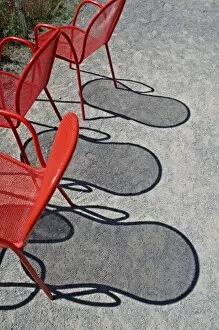 Images Dated 29th July 2007: Red wire chairs shadows on concrete