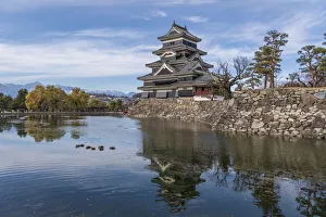 The reflection of the Matsumoto Castle and the castle against the mountain backdrop in