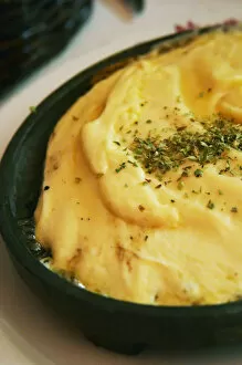 Regional dish of melted cheese on an iron plate with herbs, in the restaurant El Palenque