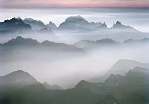 Lee Mann Prints: The rugged peaks of North Cascades National Park seen through mist with a band of