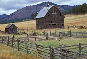 Rustic wooden barn on slopping yellow-grassed hill in eastern Washington