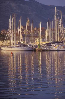 Sailboat masts light up in the early morning light in Korculas Eastern Harbor