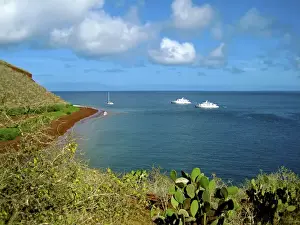 Miva Stock Prints: A sailboat and yachts with tourists along Coastline of the Galapagos Islands of Ecuador