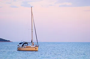 Images Dated 8th July 2006: A sailing boat moored in the bay with two people on the deck off Korcula at sunset