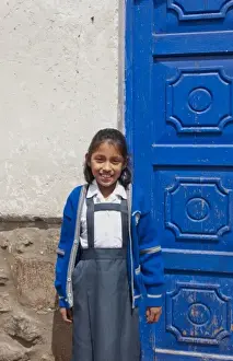 Images Dated 2028: School child aged 10 in uniform and blue door in small town of Pisaq Peru (MR)