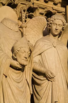 Sculpture on facade of Notre Dame Cathedral of Saint Denis after his martyrdom by decapitation