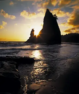Olympics Prints: A seastack juts skyward with the setting suns rays streaking through a cleft in the rock