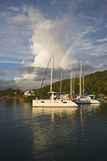 Seychelles, La Digue Island, La Passe, harbor at dusk with rainbow