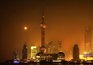 Shanghai Pudong Chna Skyline at Night with TV Tower with Moon and Reflections Orange