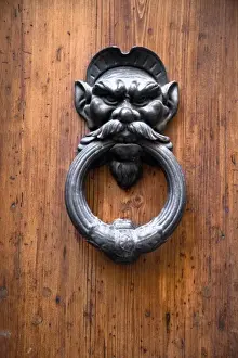 Inti St Clair Prints: Sienna, Tuscany, Italy - Closeup of a metal door knocker in the shape of a mans face