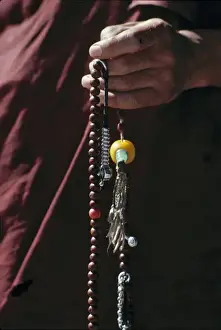 Buddhism Prints: Sikkim, Gangtok. A monk holds graceful prayer beads at Rumtek Monastery, Gangtok, Sikkim