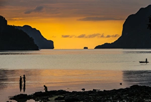 Silhouette of boys fishing at sunset in the bay of El Nido, Bacuit Archipelago, Palawan